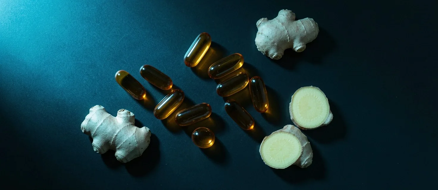 Natural supplement capsules on a dark reflective surface